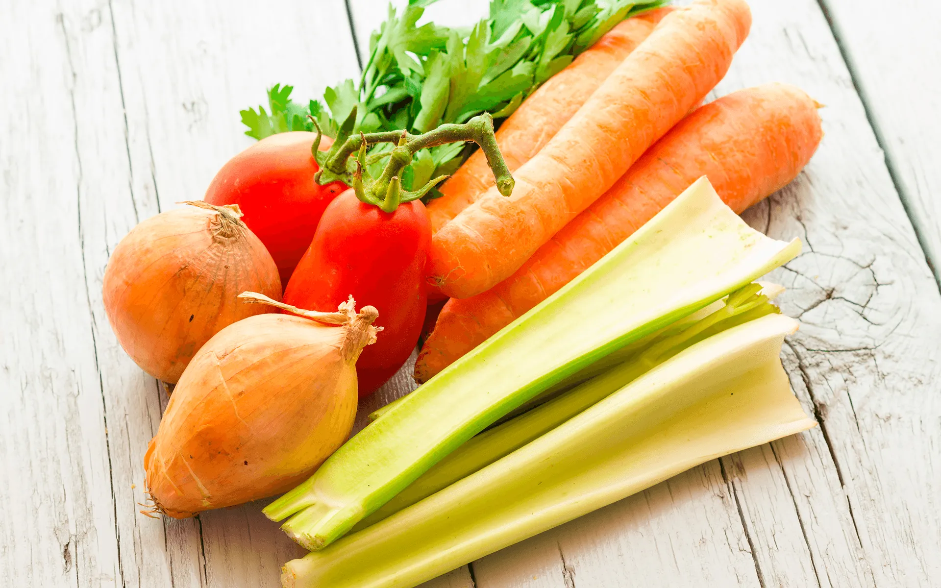 l'immagine mostra Cipolle, carote, pomodori, sedano freschi: ingredienti base del minestrone leggerezza Orogel. Un must per una cucina veloce, leggera e sana.