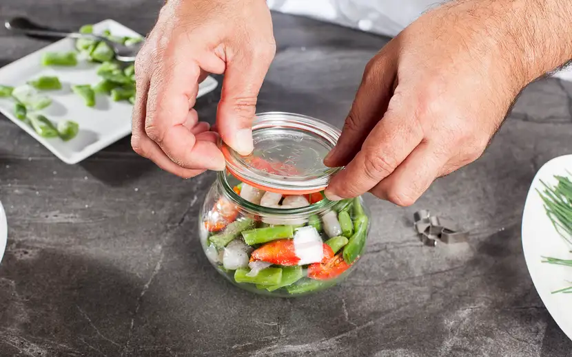 La vasocottura nella ristorazione: una persona prepara un'insalata in barattolo per il servizio.