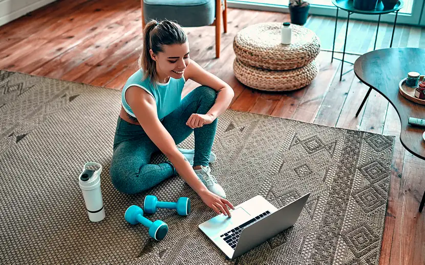Cosa mangiare prima dell'allenamento: una donna consulta il laptop per consigli nutrizionali.
