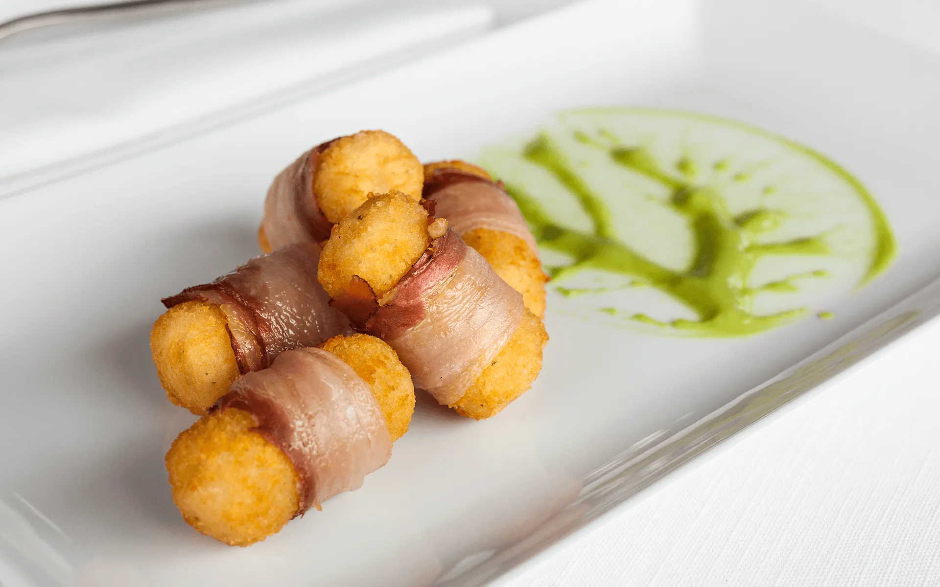  L'immagine mostra le Patate Croquettes Cilindriche Orogel cucinate con del bacon, un contorno perfetto per una ricetta veloce e gustosa.