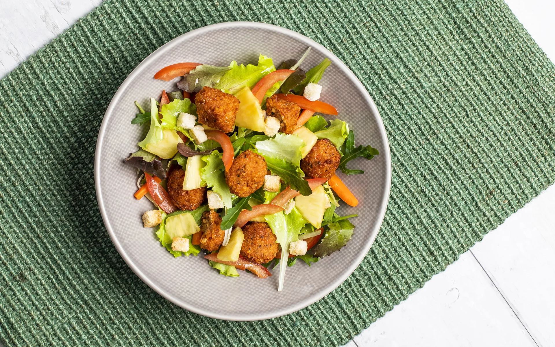 l'immagine mostra un piatto di insalata con polpette proteiche al pomodoro Orogel.